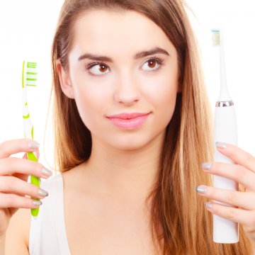 Woman holding two toothbrushes